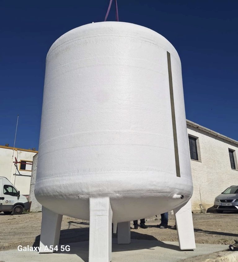 Depósito vertical blanco con tres apoyos de poliéster durante su descarga